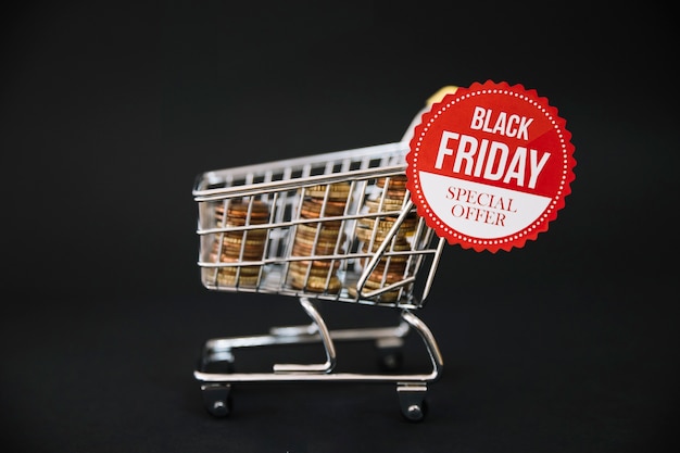 Monedas en carro de compras con etiqueta de black friday