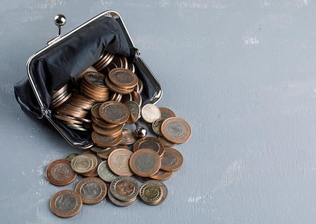 monedas dispersas de la cartera sobre la mesa de yeso.