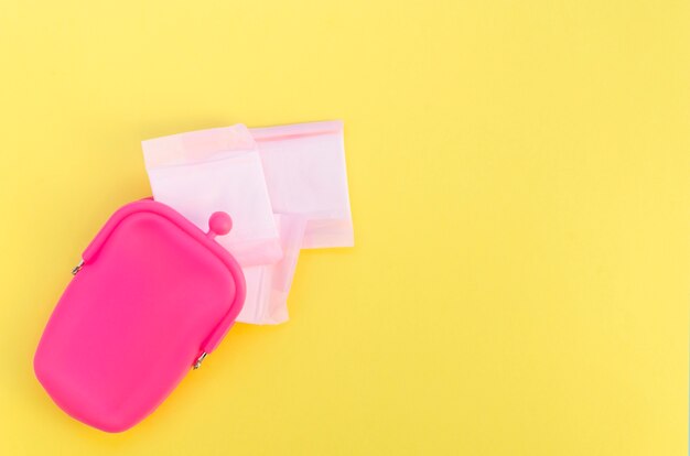 Monedero rosa con compresas sanitarias envueltas