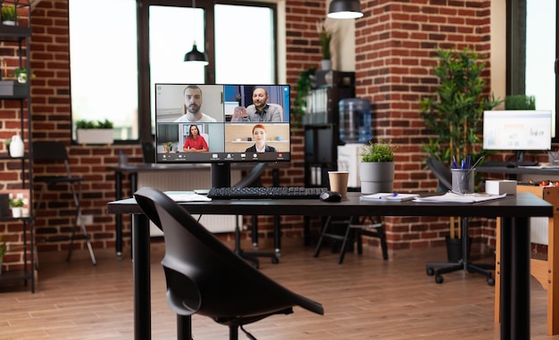 Monitor con videoconferencia en mesa en lugar de trabajo vacío. Reunión de negocios en línea con videoconferencia en computadora para comunicación remota con compañeros de trabajo. Llamada de teleconferencia
