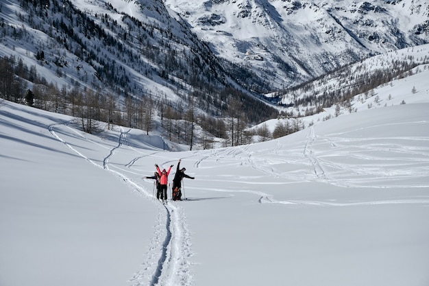 Montaña boscosa cubierta de nieve y gente caminando en Col de la Lombarde