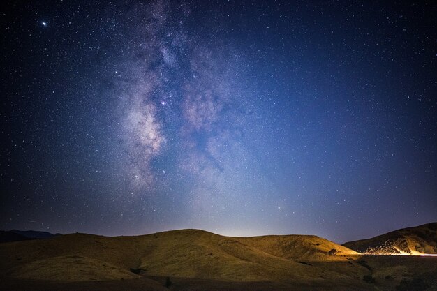 Montaña marrón bajo un cielo azul durante la noche