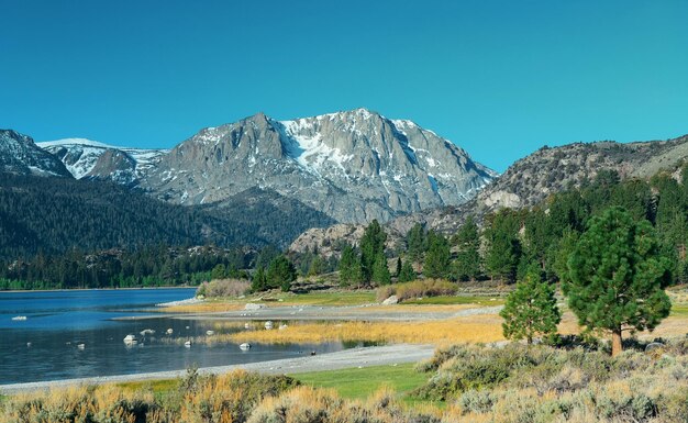 Montaña nevada y lago con reflejos en Yosemite.