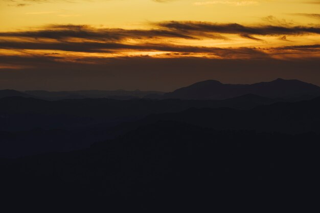 Montaña panorámica y dramático fondo de puesta de sol del cielo en dorado