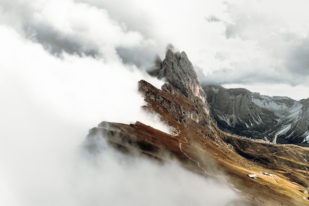 Montaña rocosa gris bajo nubes blancas durante el día