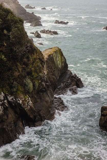 Montaña rocosa marrón junto al cuerpo de agua durante el día