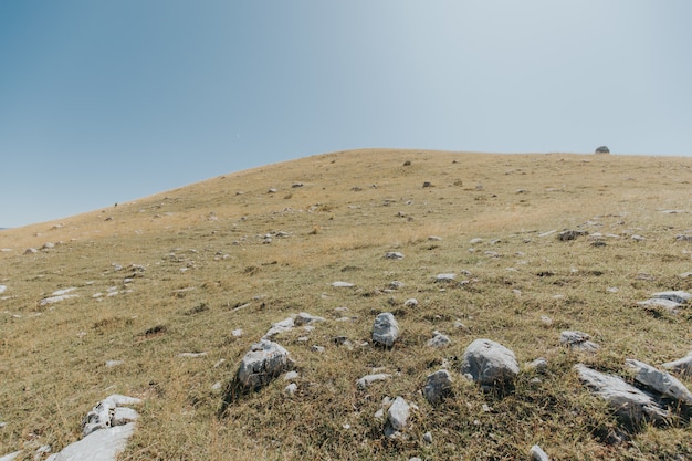 Foto gratuita montañas y colinas con muchas rocas bajo el hermoso cielo azul