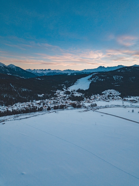 Foto gratuita montañas cubiertas de árboles y nieve durante la puesta de sol por la noche