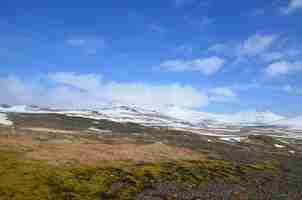 Foto gratuita montañas cubiertas de nieve heladas en un campo de rocas negras