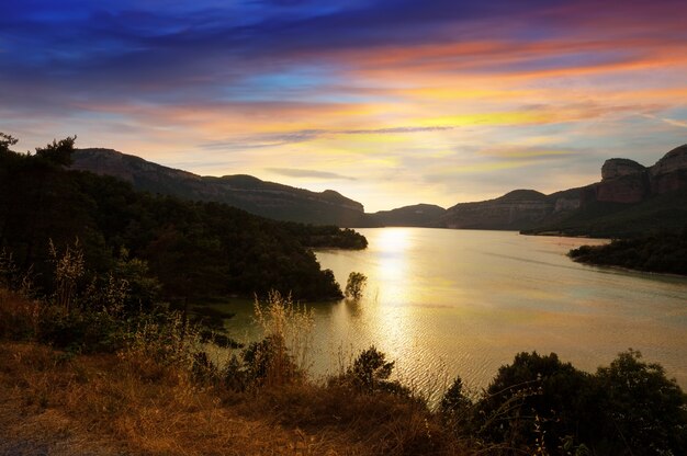 montañas lago en puesta del sol. Depósito de sau