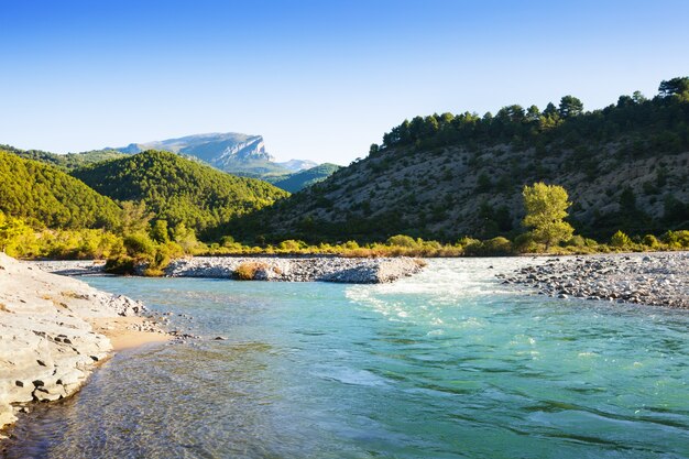 Montañas río con ribera rocosa