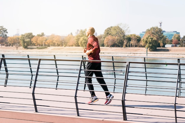 Montar atleta masculino corriendo al aire libre para mantenerse saludable