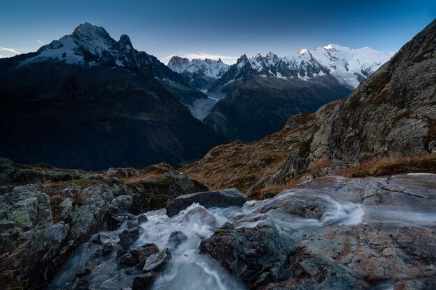 Monte Mont Blanc rodeado de rocas y un río con larga exposición en Chamonix, Francia