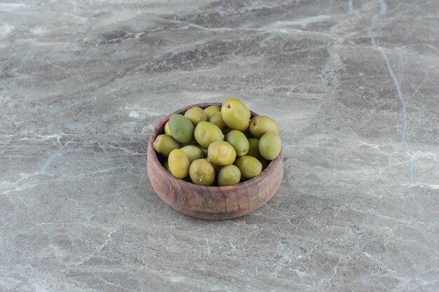 Montón de aceitunas marinadas en un tazón de madera.