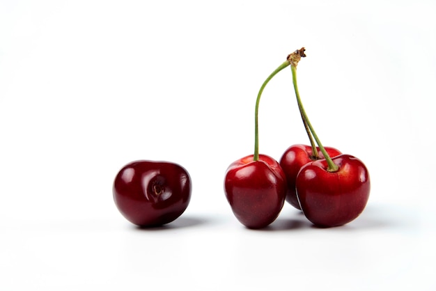 Un montón de cerezas rojas sobre fondo blanco.