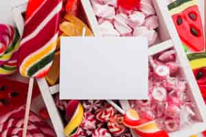 Foto gratuita montón de deliciosos dulces con tarjeta en blanco