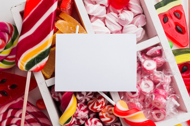 Montón de deliciosos dulces con tarjeta en blanco