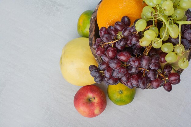 Montón de diversas frutas en balde de madera. Foto de alta calidad