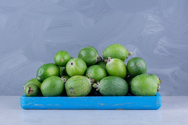 Foto gratuita montón de feijoas en una pequeña bandeja sobre fondo de mármol.