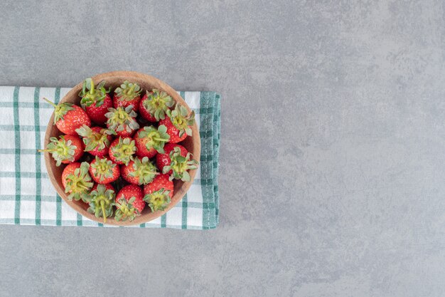 Montón de fresas frescas en un tazón de madera. Foto de alta calidad