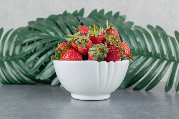 Foto gratuita montón de fresas rojas en un tazón blanco. foto de alta calidad