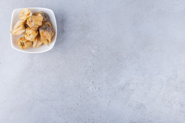 Montón de frutos secos saludables cumquat colocado sobre una mesa de piedra.