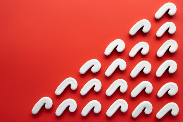 Foto gratuita un montón de galletas en forma de caña de caramelo sobre un fondo rojo