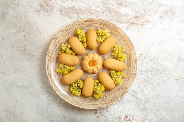 Montón de galletas en un plato con flores de color amarillo brillante en un mármol