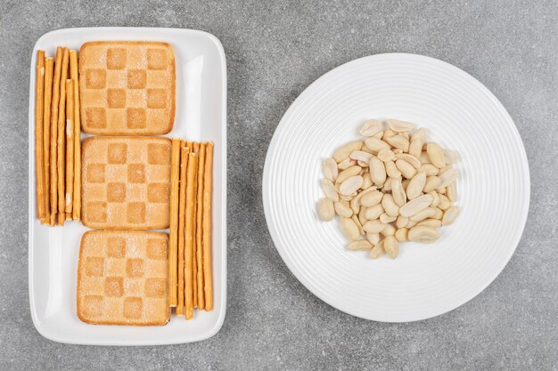 Montón de galletas y pretzels en placa blanca con anacardo