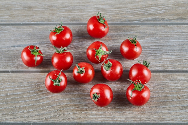 Montón de jugosos tomates frescos en la mesa de madera.