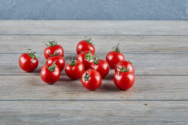 Montón de jugosos tomates frescos en la mesa de madera.