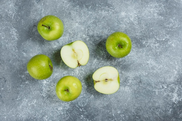 Montón de manzanas verdes sobre fondo de mármol.