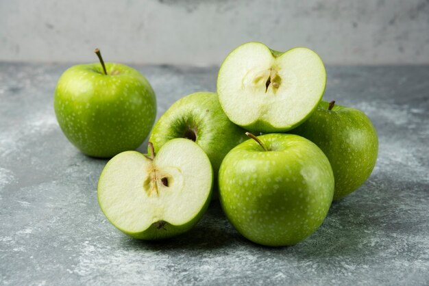 Montón de manzanas verdes sobre mármol.