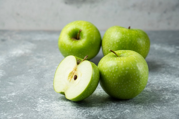 Montón de manzanas verdes sobre mármol.