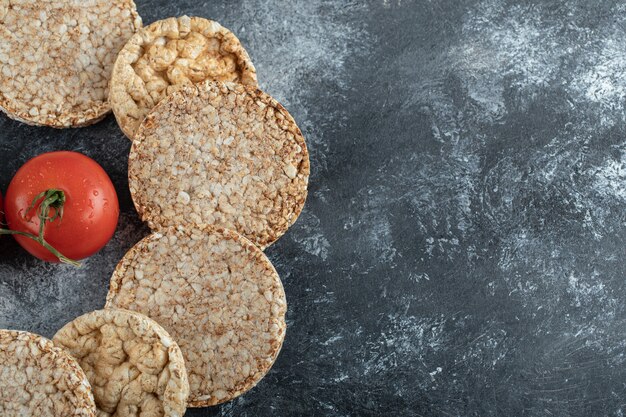 Montón de pan tostado y tomate fresco sobre la superficie de mármol