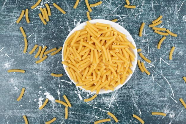 Montón de pasta cruda en un tazón blanco. Foto de alta calidad