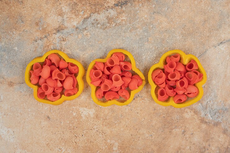 Foto gratuito montón de pasta en rodajas de pimiento sobre fondo naranja
