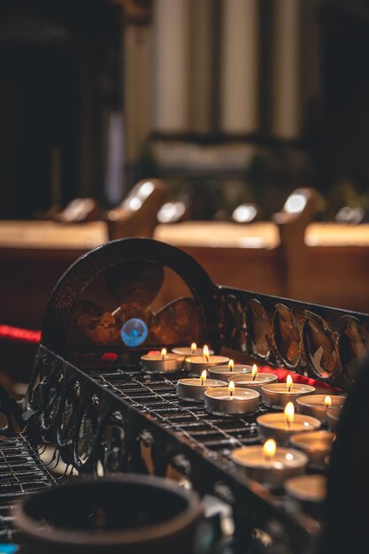 Un montón de pequeñas velas en una iglesia católica