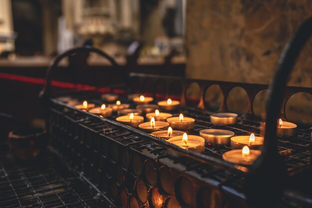Un montón de pequeñas velas en una iglesia católica