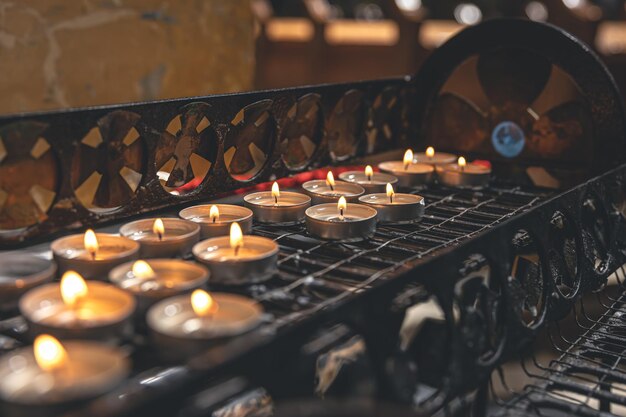 Un montón de pequeñas velas en una iglesia católica