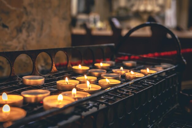 Un montón de pequeñas velas en una iglesia católica