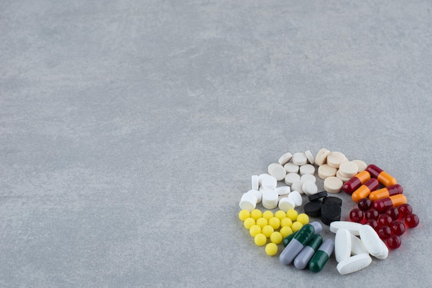 Un montón de píldoras médicas de colores en gris