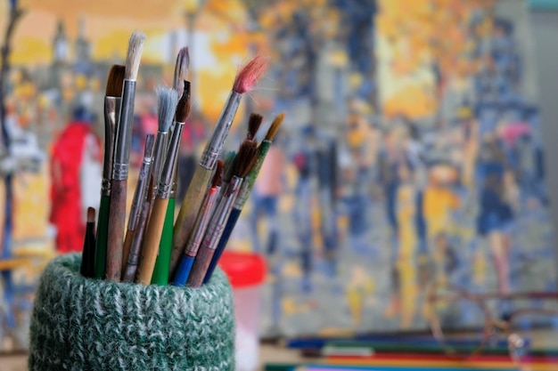 Un montón de pinceles para pintar sobre un hermoso fondo colorido de una pintura