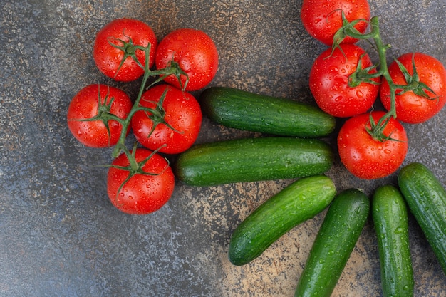 Montón de tomates y pepinos en mármol