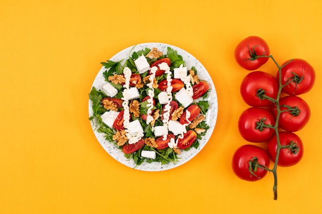 Montón de tomates rojos cerca de la deliciosa ensalada de verduras