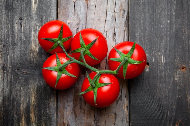 Un montón de tomates sobre un fondo de madera vieja. vista superior.