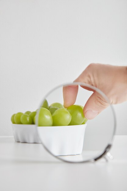 Montón de uvas moscatel verde sin semillas superalimento orgánico antioxidante en concepto de tazón de cerámica para una alimentación saludable y nutrición aislado en el cuadro blanco