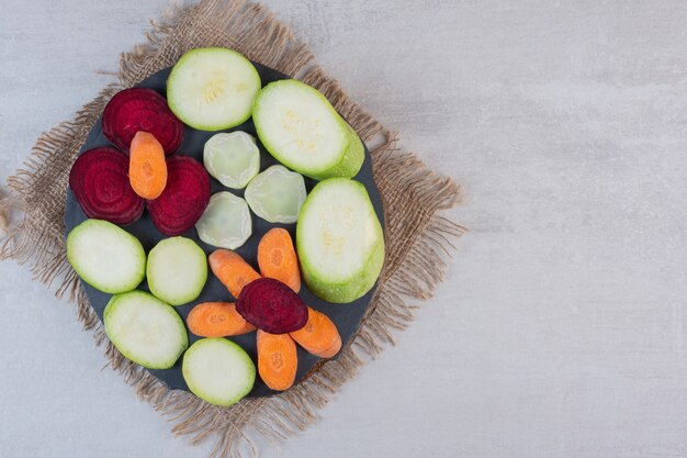 Montón de verduras crudas en rodajas en pieza de madera. Foto de alta calidad