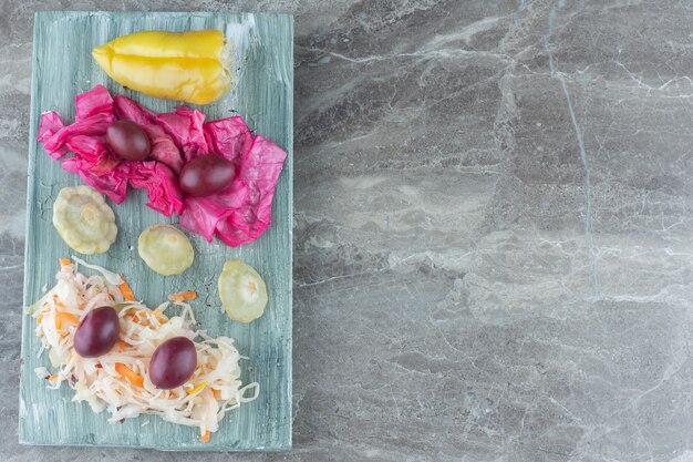 Montón de verduras en escabeche sobre tabla de madera.