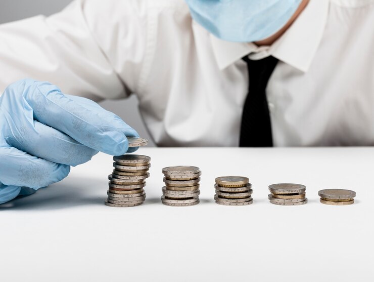 Foto gratuito montones de monedas y hombre con guantes de protección